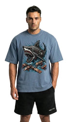 Man wearing a blue t-shirt with a shark graphic and black shorts on a white background