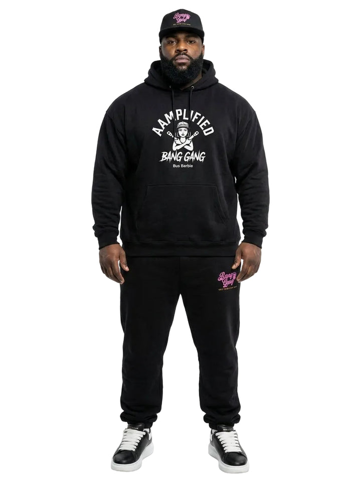Man wearing a black hoodie and pants with visible branding on a white background