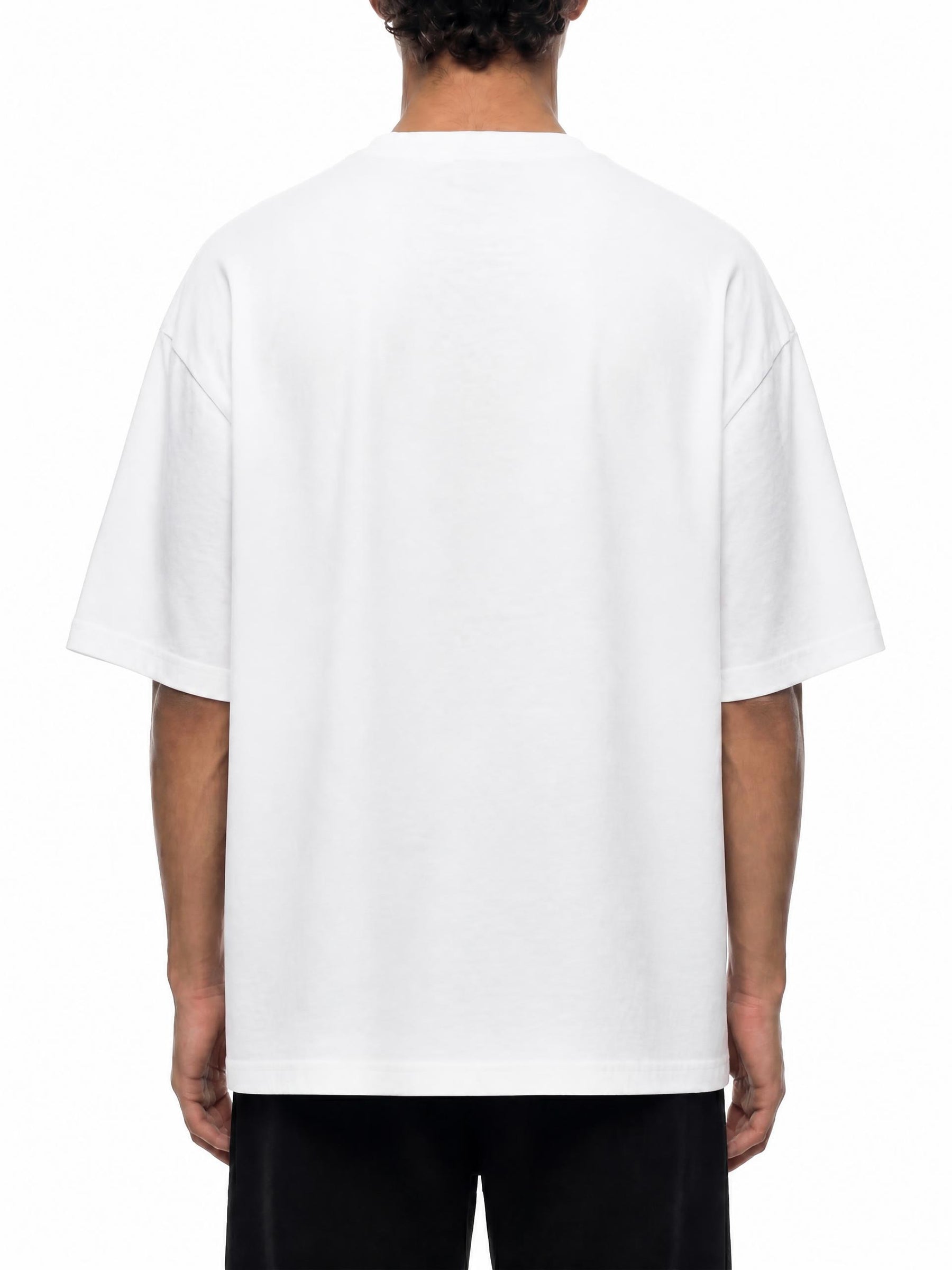 A person viewed from the back wearing an oversized white short-sleeve T-shirt and black pants against a plain white studio background.