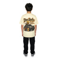 Person wearing a beige t-shirt with a graphic design on the back, standing against a white background