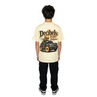 Person wearing a beige t-shirt with a graphic design on the back, standing against a white background