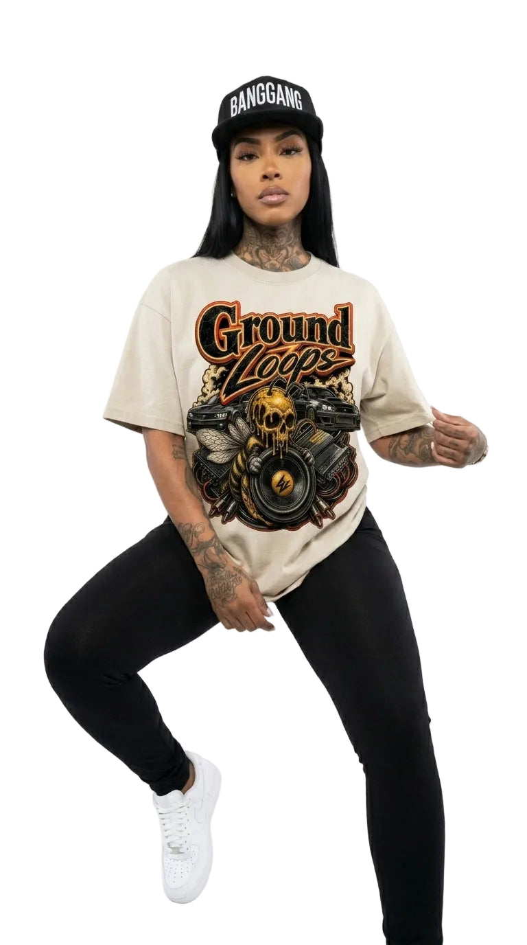 Person wearing a beige t-shirt with graphic design and text, black leggings, and white sneakers on a white background.